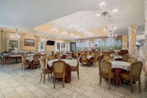 大熊湖大熊酒庄贝斯特韦斯特酒店的用餐室配有桌椅和吊灯。
