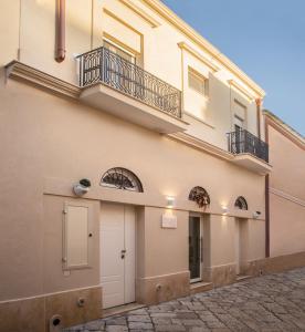 布林迪西Filia Solis - Old Town SUITEs & SPA的一侧带阳台的建筑