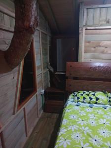 瓜杜阿斯la casita del arbol guaduas cundi.的小木屋内一间卧室,配有一张床