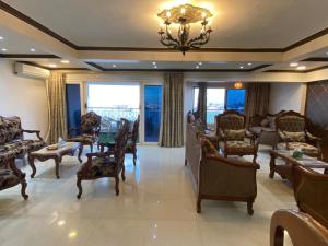 塞得港شقه مطله علي قناة السويس والبحر فيو رائع 702 بورسعيد的客厅配有桌椅和吊灯。