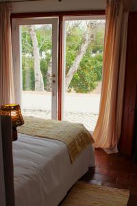 塞尔帕Horta das Laranjas的卧室在窗户前配有一张床