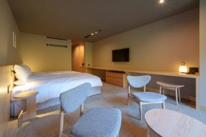 云仙市云仙宫崎旅馆 的酒店客房带一张床、椅子和电视