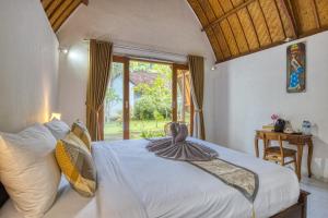 珀尼达岛Maharga Bungalows的卧室配有白色的床和窗户。