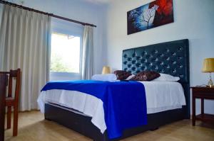 VillamontesHotel Tuunteytas的一间卧室配有蓝色的床和蓝色床头板