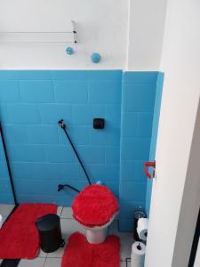 桑托斯Sala living na Av da Praia.的一间带红色卫生间和蓝色瓷砖的腿部浴室