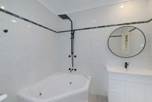 North AvocaThe Acreage Boutique Guesthouse的白色的浴室设有浴缸和镜子