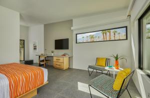棕榈泉Twin Palms Resort - A Gay Men's Resort的一间卧室配有一张床、一张书桌和一台电视。