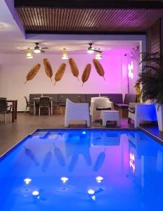 圣安娜Remfort Hotel的游泳池配有紫色照明和桌椅