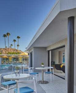 棕榈泉Twin Palms Resort - A Gay Men's Resort的一个带桌椅的庭院,棕榈树