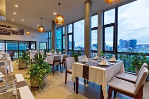 金边Indra Hotel的餐厅设有桌椅和大窗户。
