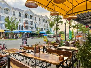 富国BISTRO HOTEL Grand World Phú Quốc的城市街道上带桌椅的户外咖啡厅