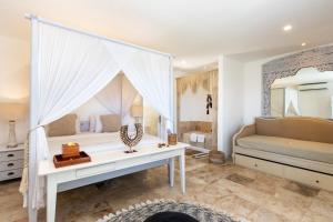乌鲁瓦图Villa Puri Balangan的卧室配有一张白色的床、一张桌子和一面镜子
