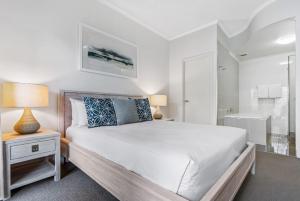 穆卢拉巴米拉查那酒店的白色的卧室设有一张大床和一间浴室。