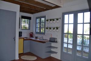 FleurimontLa Petite Kaz Dans la Savane的厨房配有柜台、水槽和窗户。