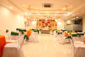 巴雷利Hotel Darbar-E-Khas A member of Crimson Hotels的一个带白色和绿色椅子的宴会厅