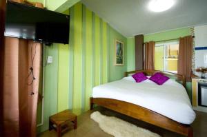 考科摩尔布里度假酒店的一间卧室配有一张带紫色枕头的床