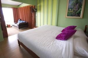考科摩尔布里度假酒店的卧室配有白色床和紫色枕头