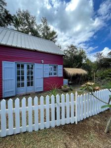 FleurimontLa Petite Kaz Dans la Savane的白色围栏的红色房子
