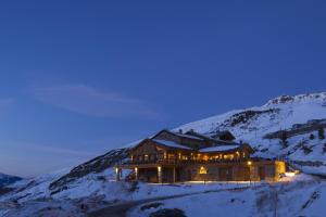 里蒙纽耶希拉里酒店的夜晚在白雪 ⁇ 的山顶上的房子