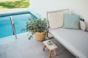 波托什Magnolia Villas Thassos的游泳池旁的沙发和凳子