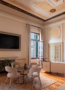 威尼斯Palazzo Maria Formosa的客厅配有桌椅和电视。