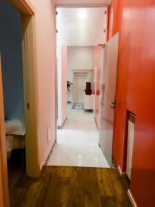 那不勒斯Hotel Ausonia的走廊上设有橙色墙壁和白色地板