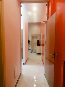 那不勒斯Hotel Ausonia的走廊上设有橙色墙壁和瓷砖地板的办公室