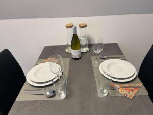拉珀斯维尔-约纳Tolles Studio im Zentrum von Rapperswil的一张带盘子和玻璃杯的桌子和一瓶葡萄酒