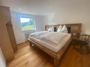 布莱夏Gipfel Stuben的一间卧室配有一张带白色床单的床和一扇窗户。
