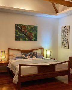 DimiaoVilla MountainView Guesthouse的卧室配有一张床,墙上挂有绘画作品