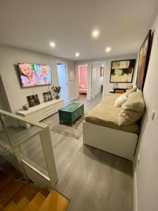圣塞巴斯蒂安德洛斯雷耶斯Duplex acogedor y cómodo的卧室配有一张床,墙上配有电视。