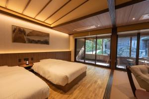 三条市嵐渓荘旅馆的一间卧室设有两张床和大窗户