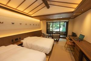 三条市嵐渓荘旅馆的客房设有两张床和一张带笔记本电脑的书桌。