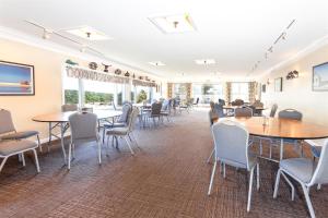 北特鲁罗Dune Crest Hotel的用餐室设有桌椅和窗户。