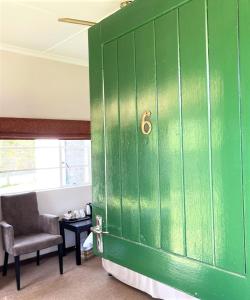 海姆维尔Himeville Arms的绿色的橱柜,配有椅子和绿门