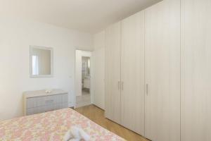 马尔泰拉戈Da Nonna Antonia的白色卧室配有一张床和白色橱柜