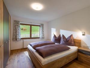 蒂罗尔-基希贝格Ferienhaus Widmann的一间卧室设有一张大床和一个窗户。