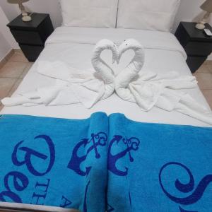 帕福斯Potamos Private Suites的一张带两条毛巾和两条天鹅毛巾的床