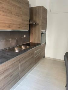 福贾Blue & Grey downtown Foggia的厨房配有木制橱柜和不锈钢盥洗盆。