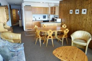 韦松纳Magrappé MOUNTAIN & CENTER apartments的厨房以及带木桌和椅子的用餐室。