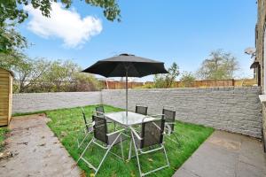 伦敦LiveStay-Stylish Two Bed House with Private Garden的院子里的桌椅和雨伞