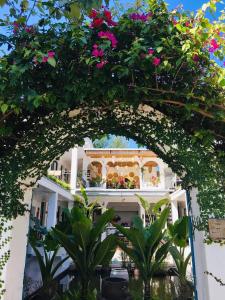 科多岛Coto Island Beach Village Homestay的鲜花建筑前的拱门