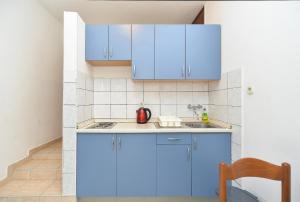 拉巴克Apartments Plominska 938的厨房配有蓝色橱柜和水槽