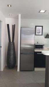 厄尔梅达诺Casa de Playa Sol Y Mar的厨房配有不锈钢冰箱和花瓶