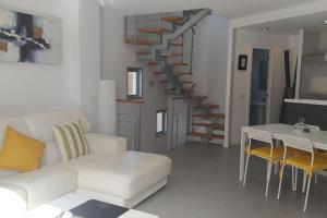 厄尔梅达诺Casa de Playa Sol Y Mar的客厅设有白色沙发和楼梯。
