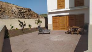 厄尔梅达诺Casa de Playa Sol Y Mar的一座带两把椅子和一张桌子的庭院以及一座建筑