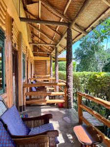 BuhomaBwindi Forest Lodge的房屋内的门廊配有桌椅