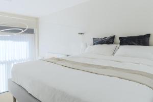 米兰Touch&Go - via Gaetano Previati 38, Milano的白色卧室内的一张白色床,设有窗户