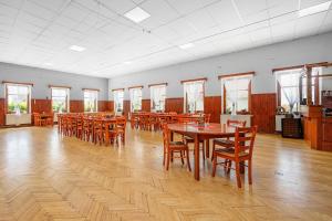 Hoření PasekySvět pod Ještědem的大型用餐室配有木桌和椅子