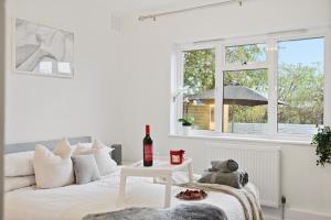 伦敦LiveStay-Stylish Two Bed House with Private Garden的白色的卧室设有白色的床和窗户。